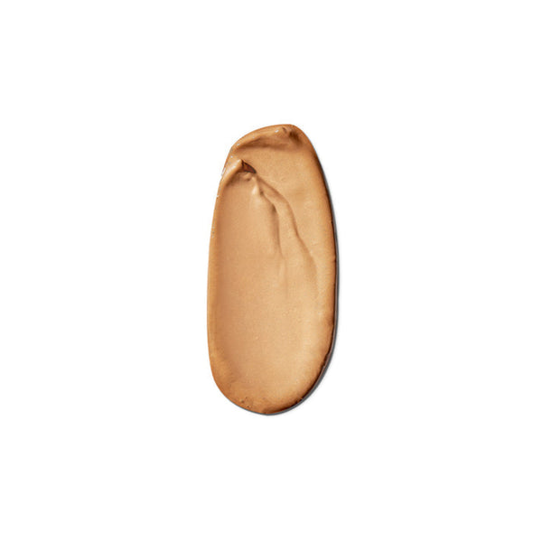 A smooth, swirled smear of light tan liquid foundation or cream makeup on a solid white background.