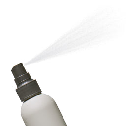 Spray bottle with a stream of liquid on a white background