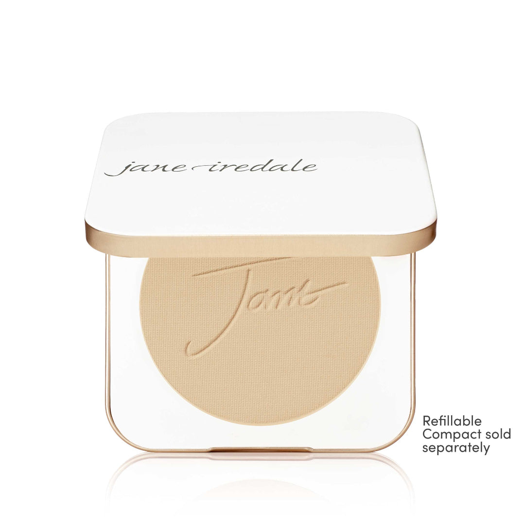A Jane Iredale makeup compact with a white lid and gold trim, showing a round beige pressed powder pan inside. Small text on the bottom right reads 'Refillable Compact sold separately'.