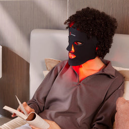 Woman Laying Down Wearing the Red Light Face Mask