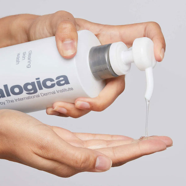 Hand holding a bottle of Logica skincare product with dropper, showing liquid being dispensed.