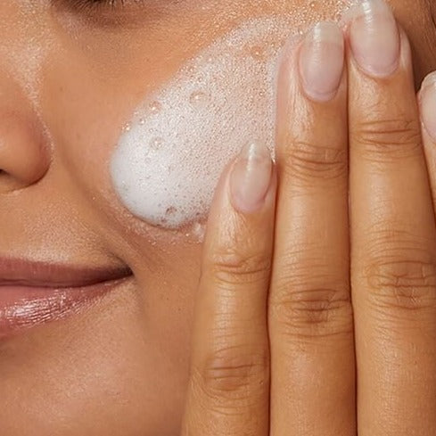 Model applying CeraVe Hydrating Cream-to-Foam Cleanser to their face