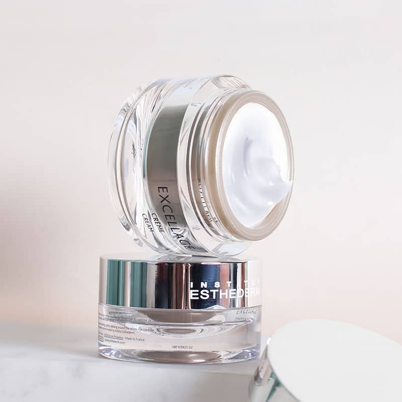 Institut Esthederm Excellage Cream placed on its side exposing its serum