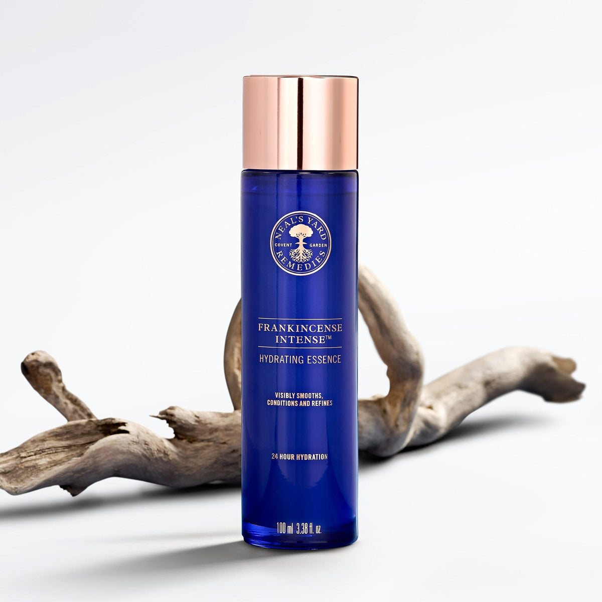 Blue skincare bottle with rose gold cap on a white background