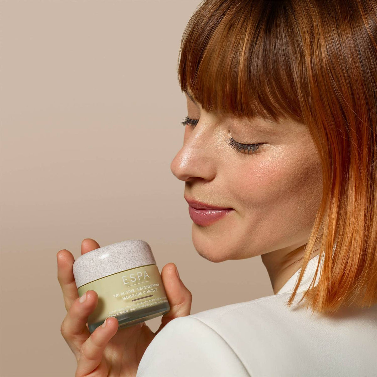 a women holding a tub of ESPA Tri-Active Regenerating Moisture Complex on her shoulder