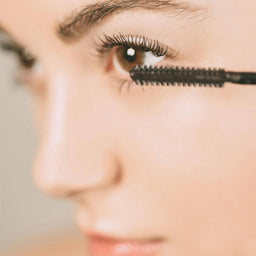 women applying mascara