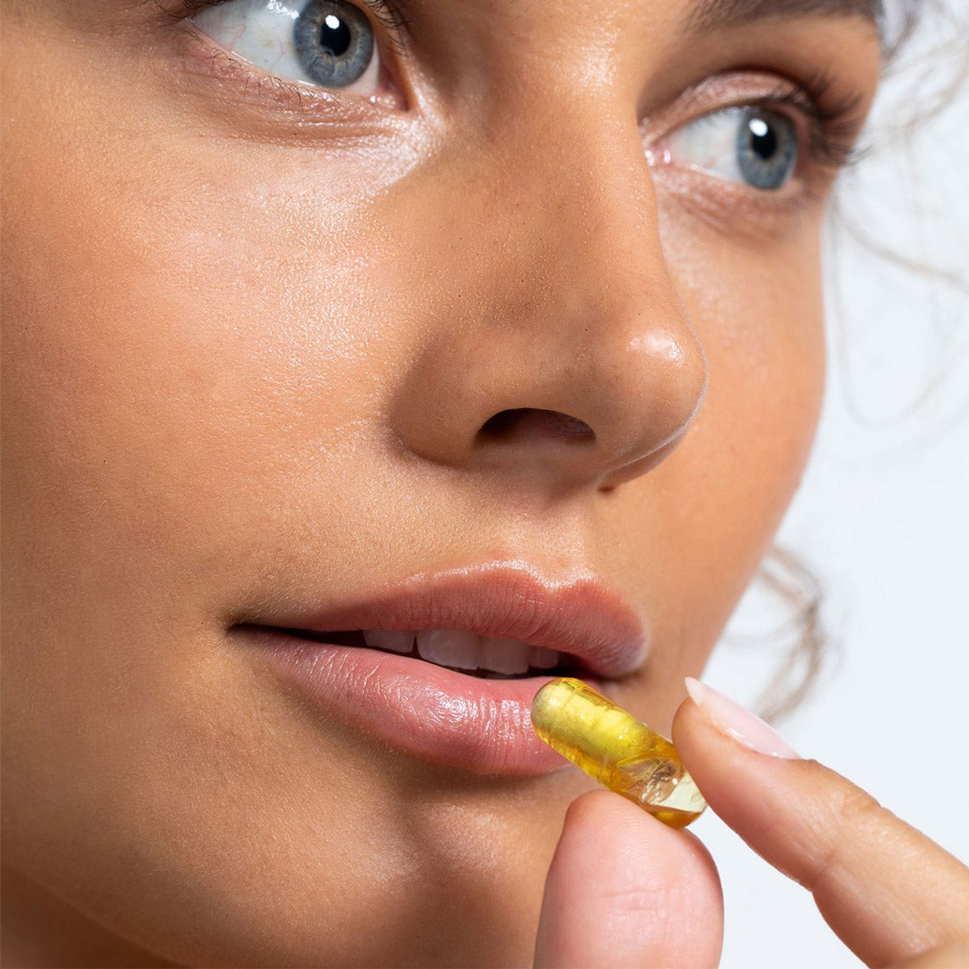 Yellow Vida Glow Clear capsule being swallowed
